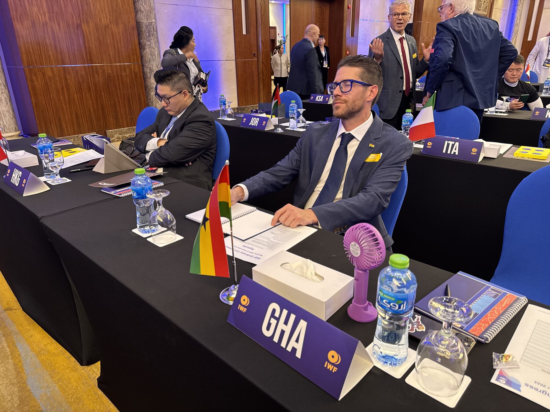 Kevin Frey seated at the Ghana delegation desk at the IWF Congress